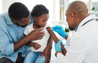 Bildet viser et barn som blir vaksinert.