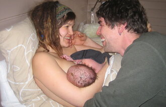 Bildet viser mor, far og nyfødt barn.