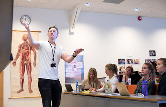 Bildet viser Nils Christian Tvedt Karlsen i en forelesningssal.