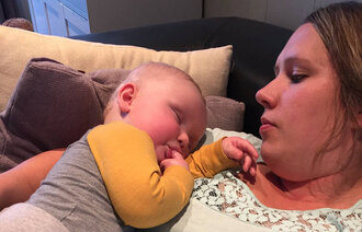 Bildet viser Mona Kampelien og hennes sønn Theodor som sover i armkroken hennes