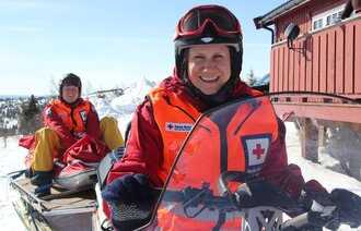 Bildet viser Cecilie Engum Blakkestad og Lars-Petter Andreassen fra Røde Kors hjelpekorps på en snøscooter.