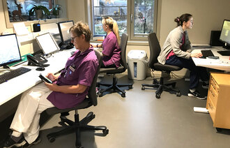 Bildet viser tre helsearbeidere i Åfjord kommune som registrerer i rapporteringsverktøyet Refleks, både via app på mobiltelefon og via pc.