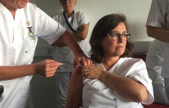 Bildet viser Jorunn Eid som setter vaksine på Anne Katrine Aas.