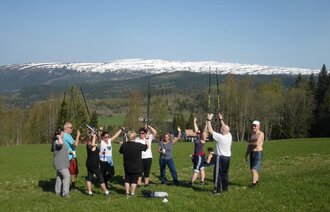 Bildet viser en gruppe pasienter som trimmer utendørs i vakker natur