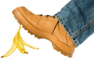 Illustrasjonsbilde av en fot som er i ferd med å skli på et bananskall