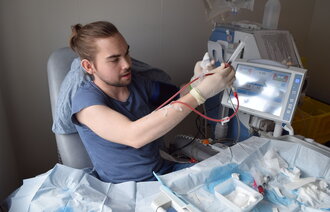Bildet viser Nikolai Raabye Haugen som klargjør hjemmehemodialysen