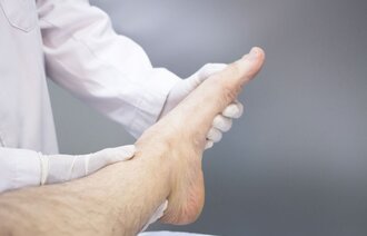 Viser ortoped som undersøker en pasients fot