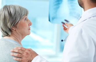 Pasient som ser på røntgenbilde sammen med lege