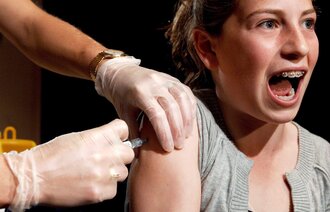 Bildet viser en jente som får vaksine.