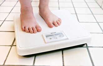 Bildet viser barneføtter på en vekt.