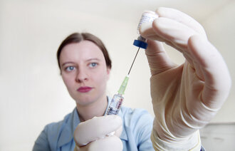 Bildet viser en sykepleier som trekker opp MMR-vaksine.