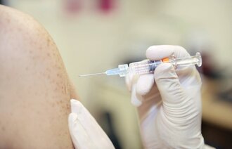 Bildet viser en overarm som det settes vaksine i.