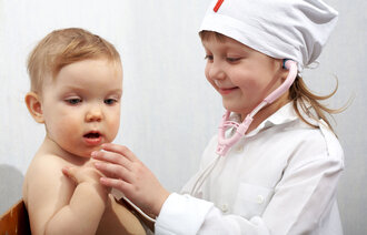 To små barn som leker sykepleier og pasient