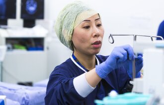Bildet viser en sykepleier på en operasjonsstue som gjør klart utstyr.