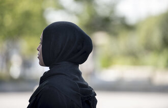 Bildet viser en kvinne med hijab, sett i profil bakfra.