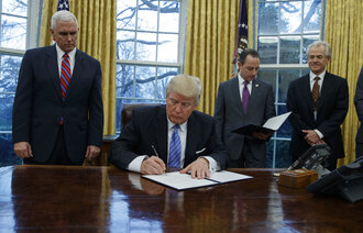 Bildet viser Donald Trump som signerer papirer.