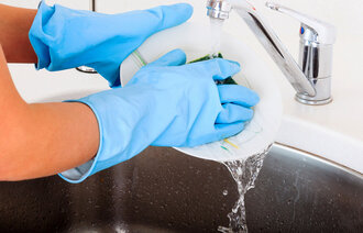Bildet viser hender som vasker opp