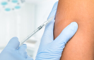 En person som får en vaksine sprøytet inn i skulderen