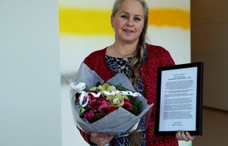 Bildet viser Målfrid J. Frahm Jensen med diplom og blomster.
