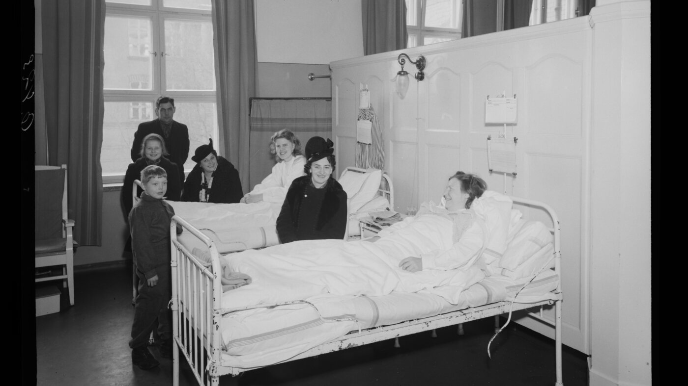 Personer samlet rundt sykeseng