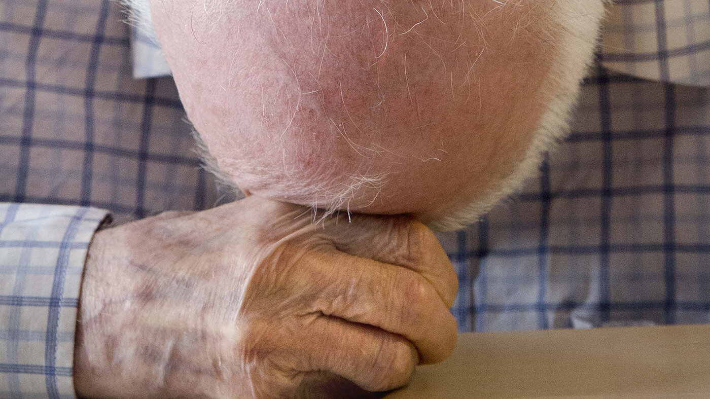 Bilde av mann som hviler hodet mot hendene