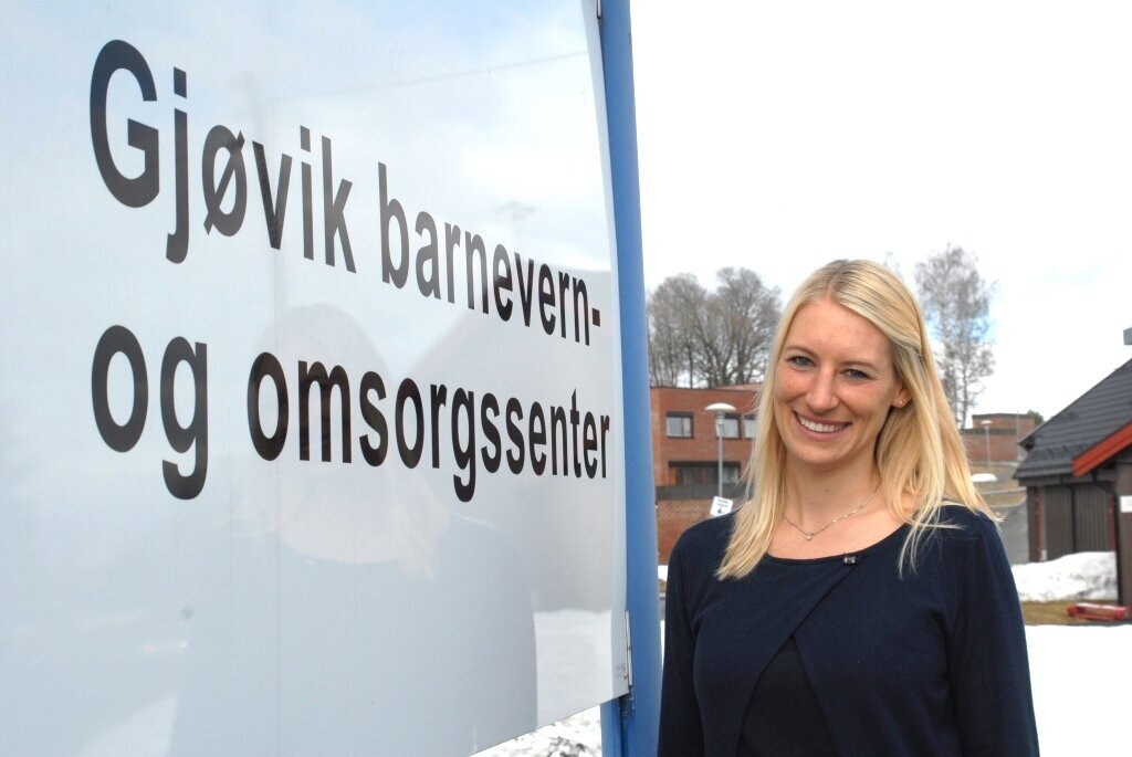 Bildet viser psykolog Silje Frivold fra Bufetat ved inngangsskiltet til Gjøvik barnevern- og omsorgssenter.