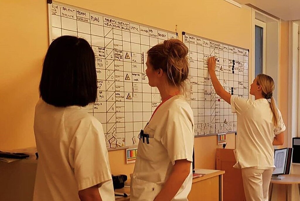Bildet viser sykepleiere som skriver og ser på en tavle.