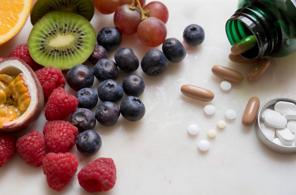 Bildet viser ulike frukter og bær samt kosttilskudd