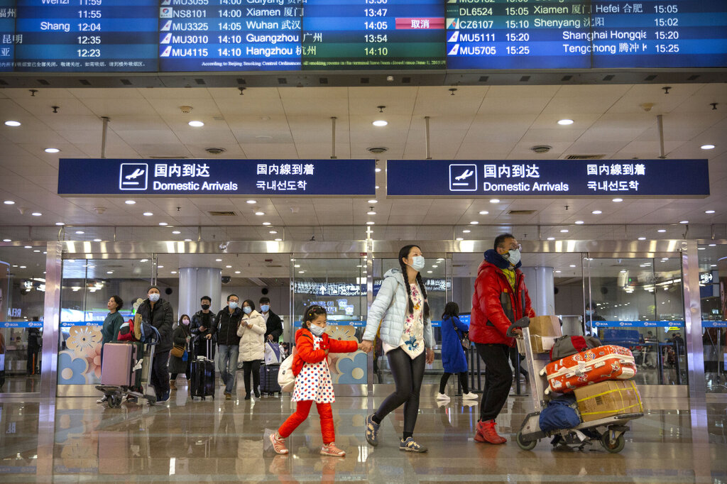 Passasjerer med fly fra Wuhan har ankommet Beijing internasjonale flyplass 23. januar. Passasjerene bruker munnbind.