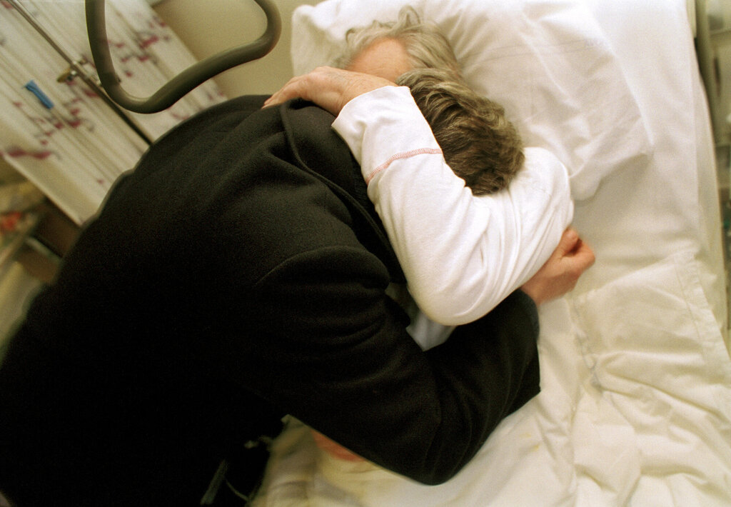 Bildet viser en pårørende som besøker eldre pasient