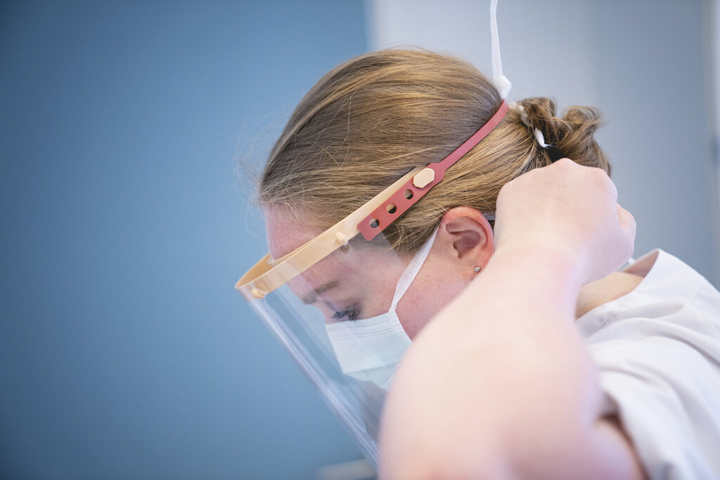 Bildet viser en sykepleiere som tar på seg øyebeskyttelse.