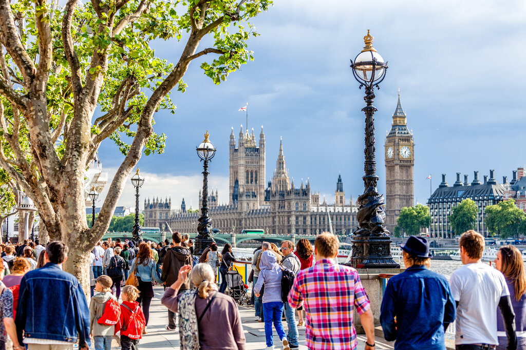 Bildet viser mennesker som går langs Themsen i London, med parlamentet i bakgrunnen