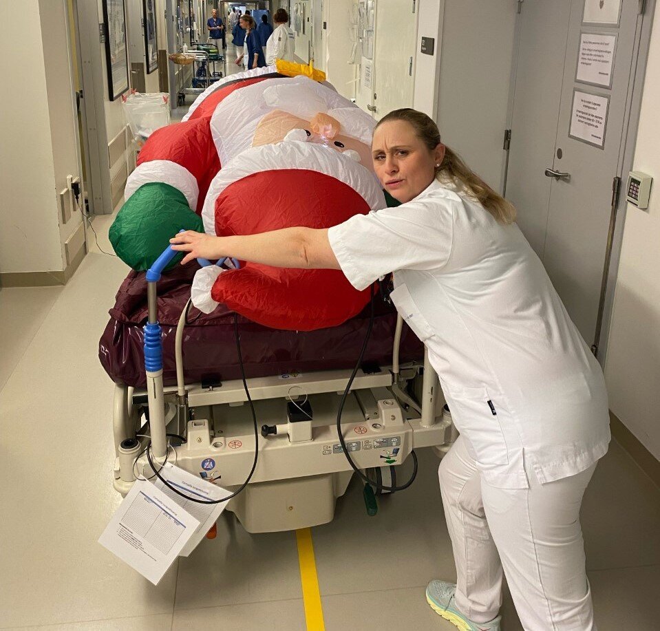 Bildet viser sykepleier Lill Heidi Anzjøn som triller plastnissen, som ligger i en seng, på intensivavdelingen på Ahus.