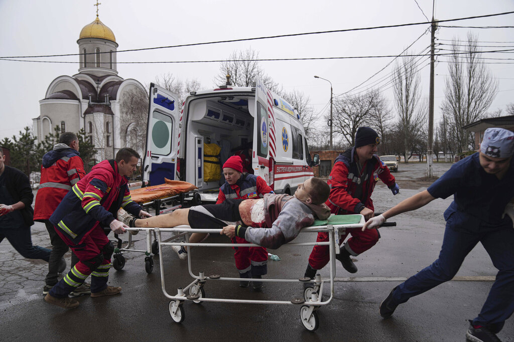 Ambulansepersonell flytter en skadet mann i et boligområde etter bombing i byen Mariupol i Ukraina.