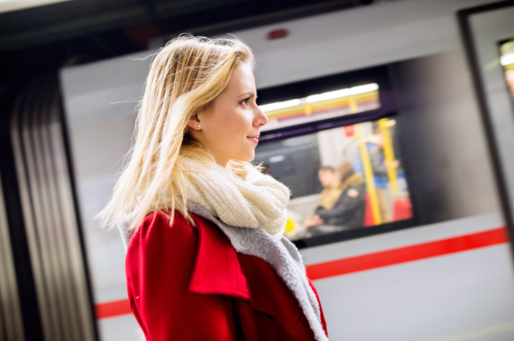 Bildet viser profilen av en ung målbevisst kvinner på en togperrong