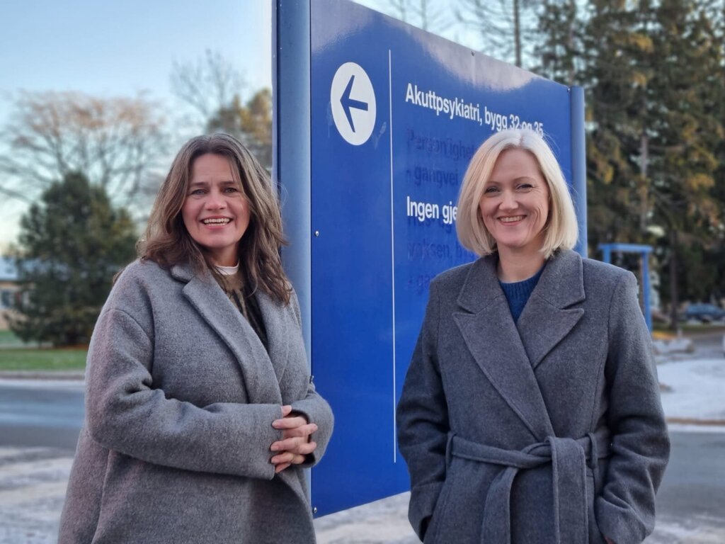 To kvinner står foran skiltet til akuttpsykiatrisk mottak på Ullevål sykehus 