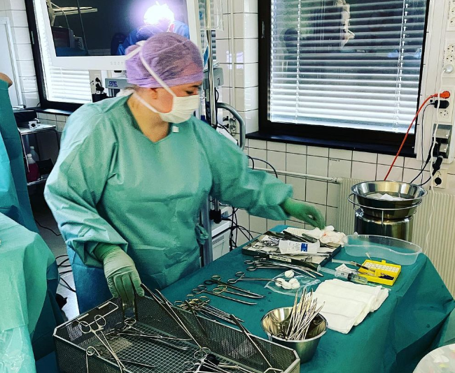 Bildet viser en operasjonssykepleier ved et instrumentbord.