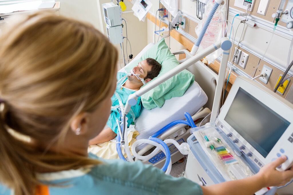 Bildet viser en intensivsykepleier som overvåker en pasient