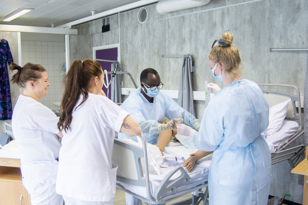 Helsesykepleierne Jean Karekezi og Kristin Olsen Holst øver på å sette inn kateter på en simuleringsdokke. De blir veiledet av slagsykepleier Adrianne Johnsen og fagutviklingssykepleier Marthe Bjørnvik.