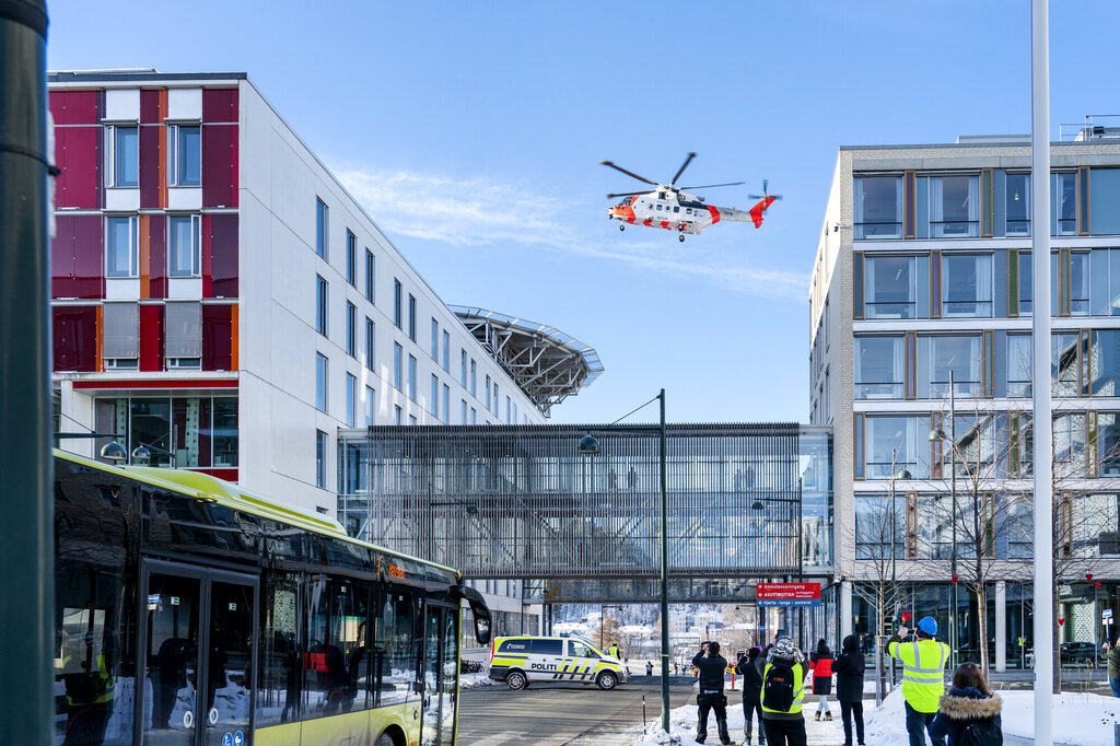 Bildet viser St. Olavs hospital i Trondheim vinters tid. Over bygningene svever et ambulansehelikopter