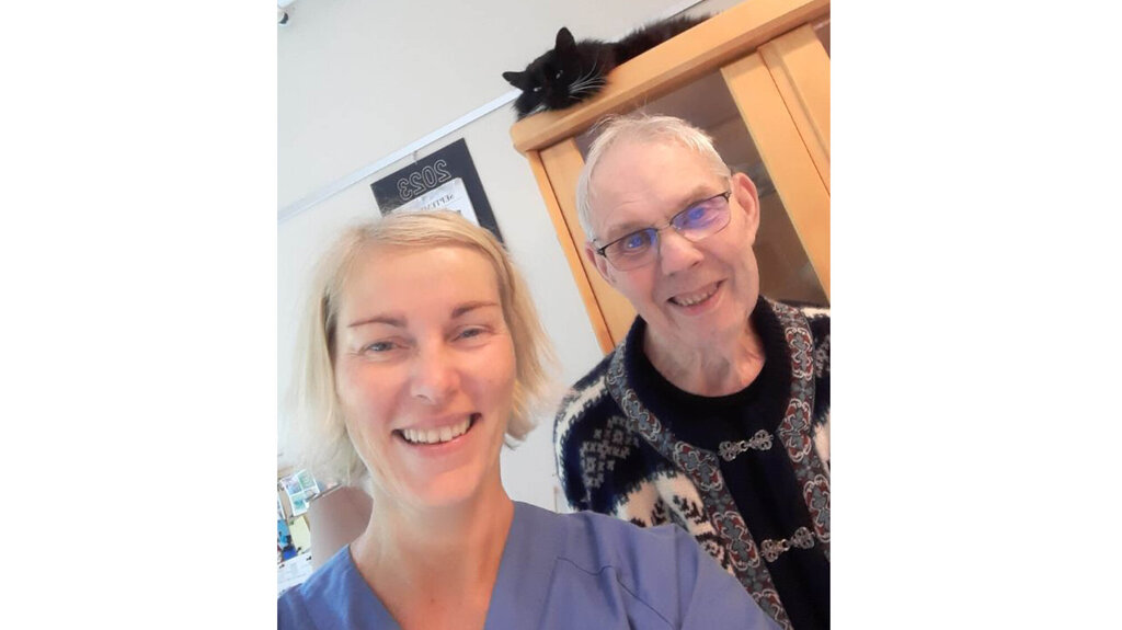 Sykepleier Tone Valle og beboer Olav Torgny Wik er glad for at katten Lukas bor fast på Åmli pleie og omsorgssenter.