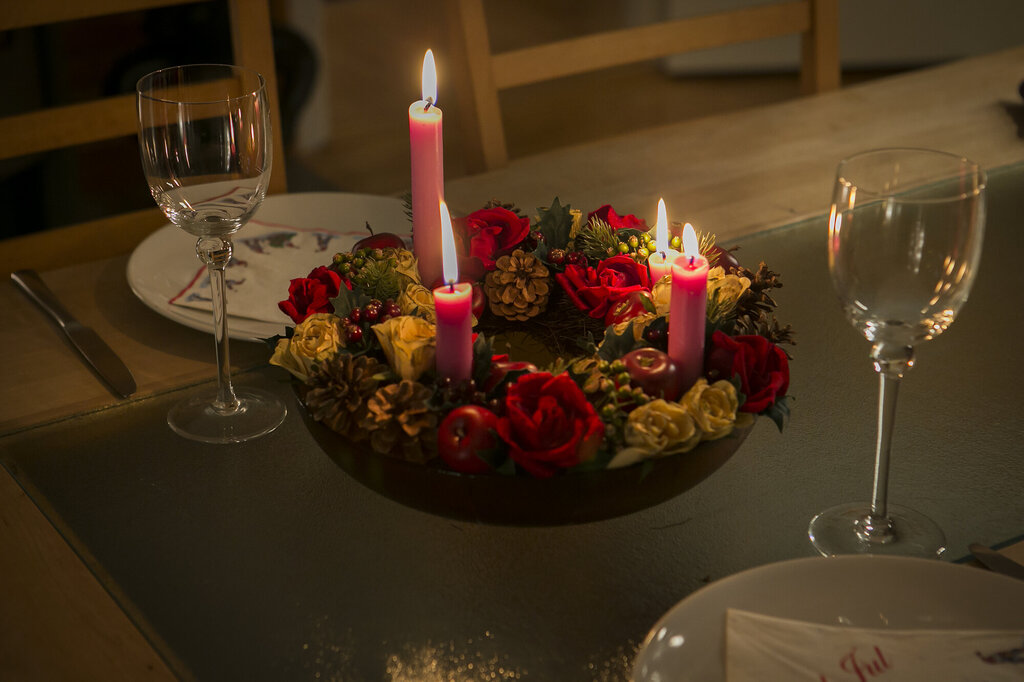 Bildet viser et middagsbord som er pyntet med julelys og blomster