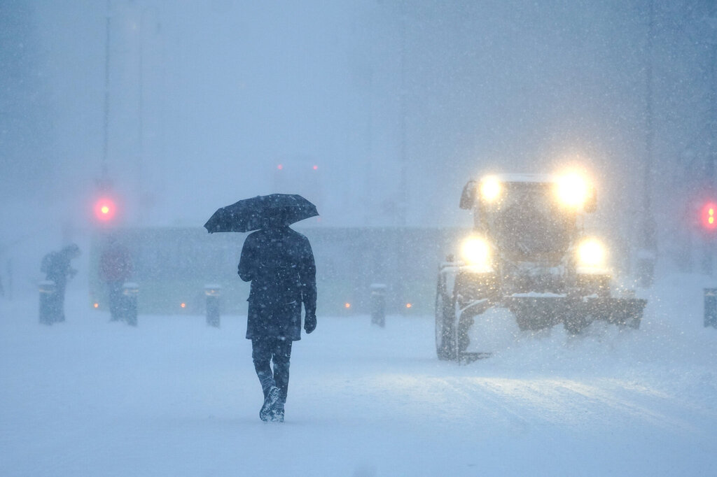 Bildet viser en mann og en brøytetraktor i et snøtett Oslo