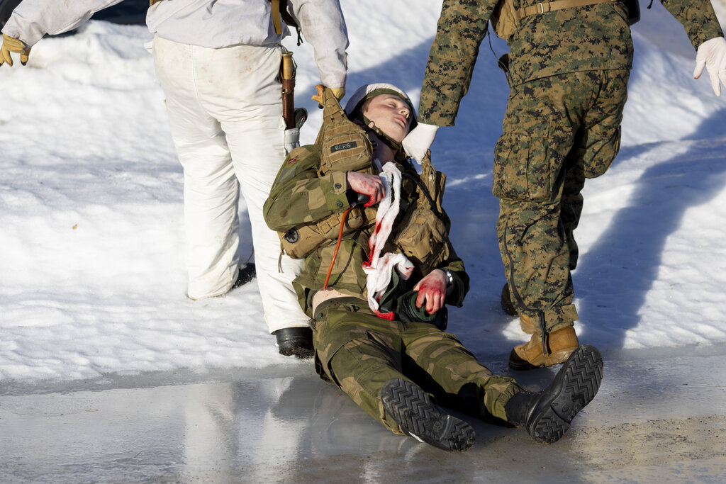 Bildet viser medic´er som sleper på en såret soldat.