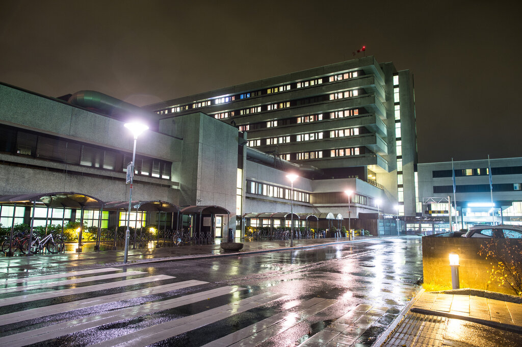 Bildet viser Stavanger universitetssjukehus (SUS) fra veistubben inn mot hovedinngangen i mørket.