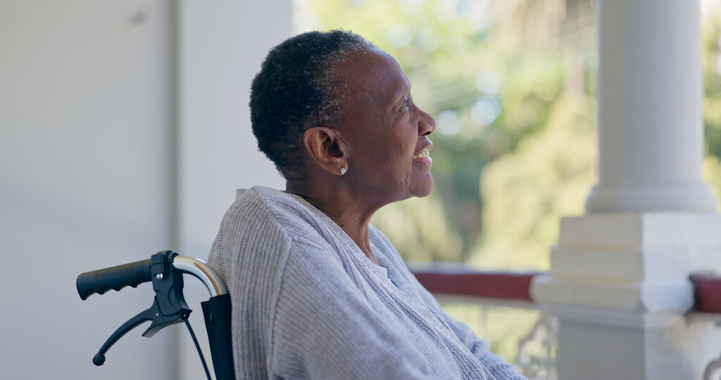 Bildet viser en eldre, afrikansk kvinne som sitter i rullestol