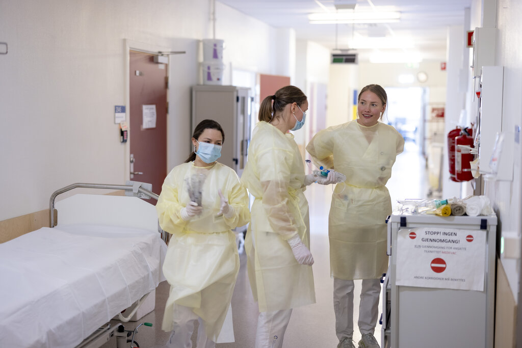 Bildet viser sykepleiere som gjør seg klare til å gå inn til pasient.