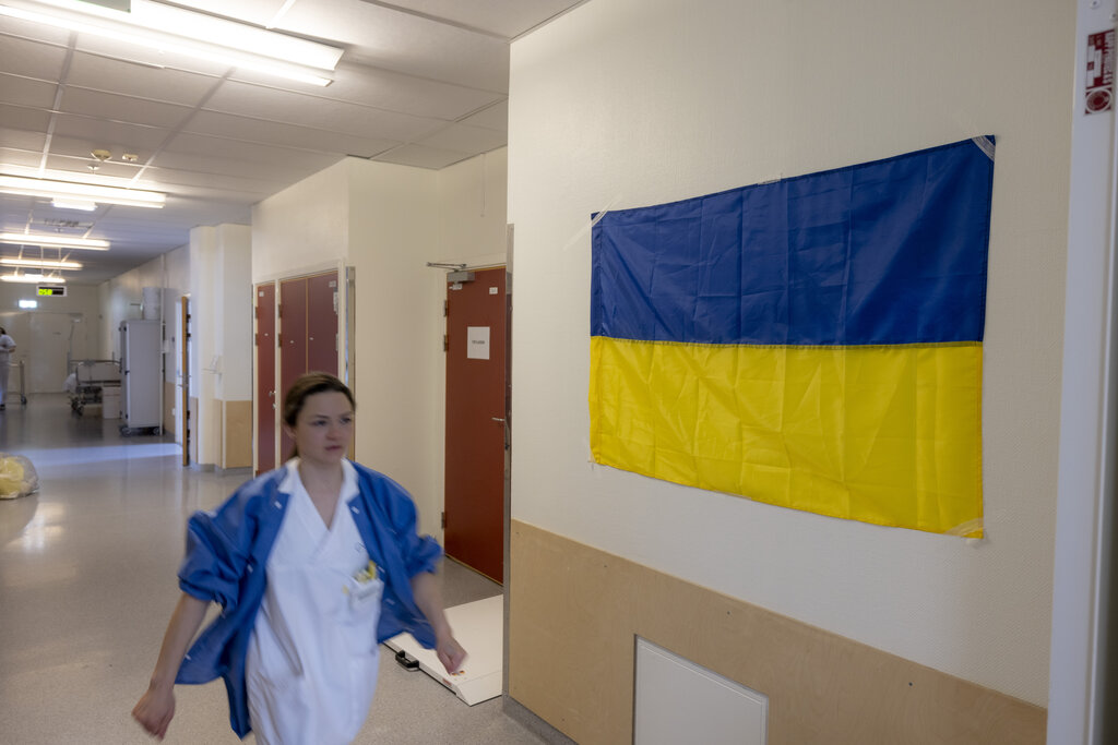 Bildet viser en sykepleier i en gang med ukrainsk flagg på veggen.