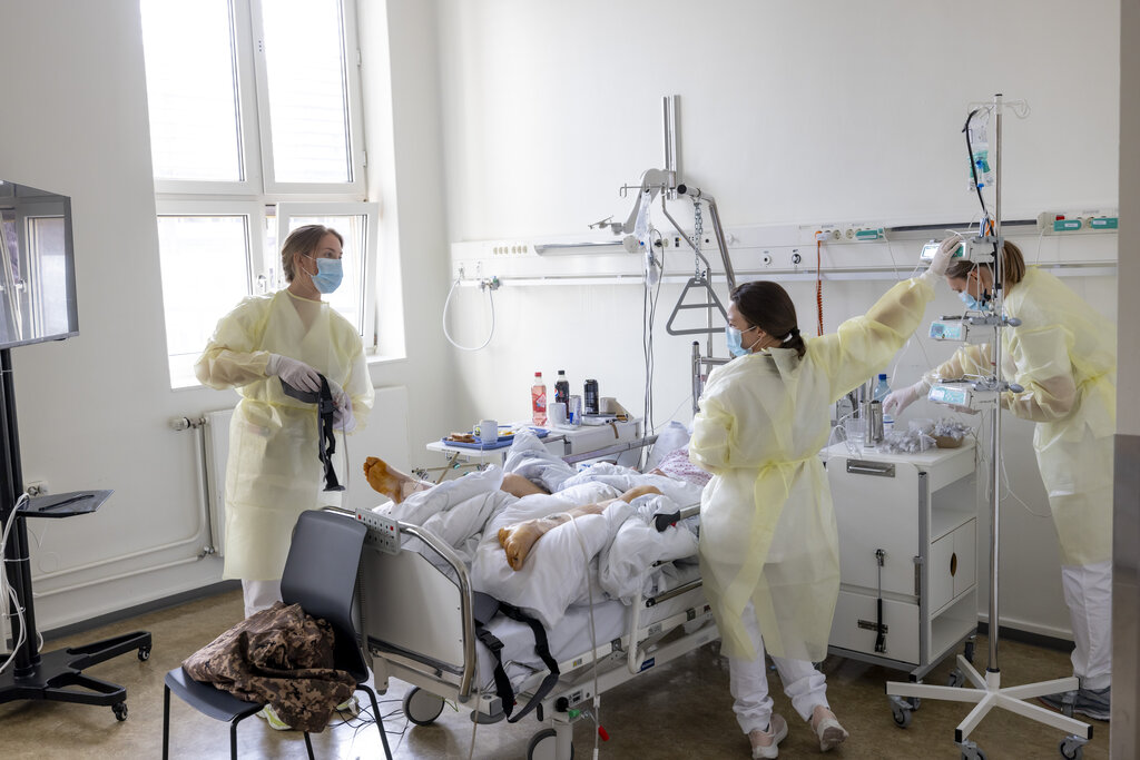 Bildet viser sykepleiere som gir pleie til pasient.