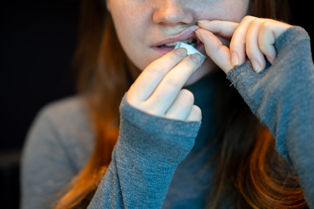 Bildet viser en ung kvinne som legger inn en pris snus.